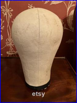 A cloth mannequin head, vintage, hat headdress wig stand, plastic base, table top.