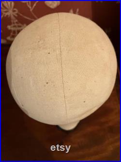 A cloth mannequin head, vintage, hat headdress wig stand, plastic base, table top.
