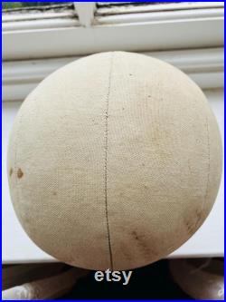 A cloth mannequin head, vintage, hat headdress wig stand, plastic base, table top.